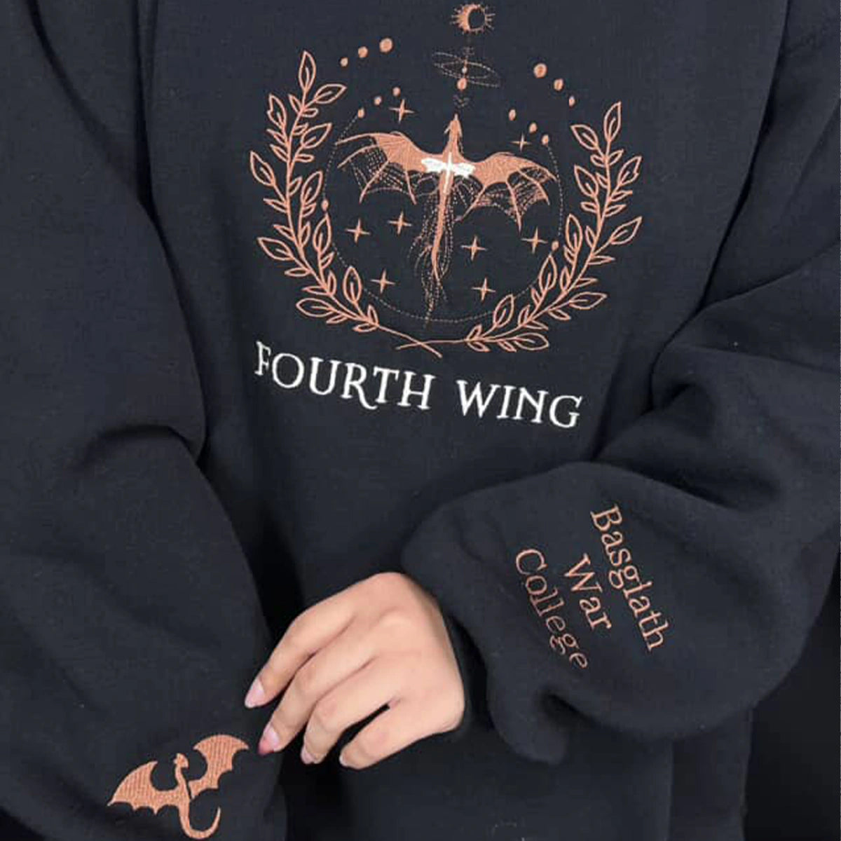 Black sweatshirt with 'Fourth Wing' design and bat emblem on a person wearing it.