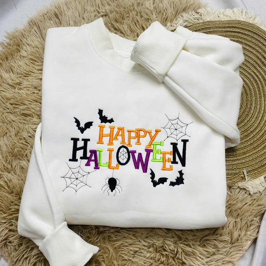 White hoodie with 'Happy Halloween' text and spider webs on a textured surface