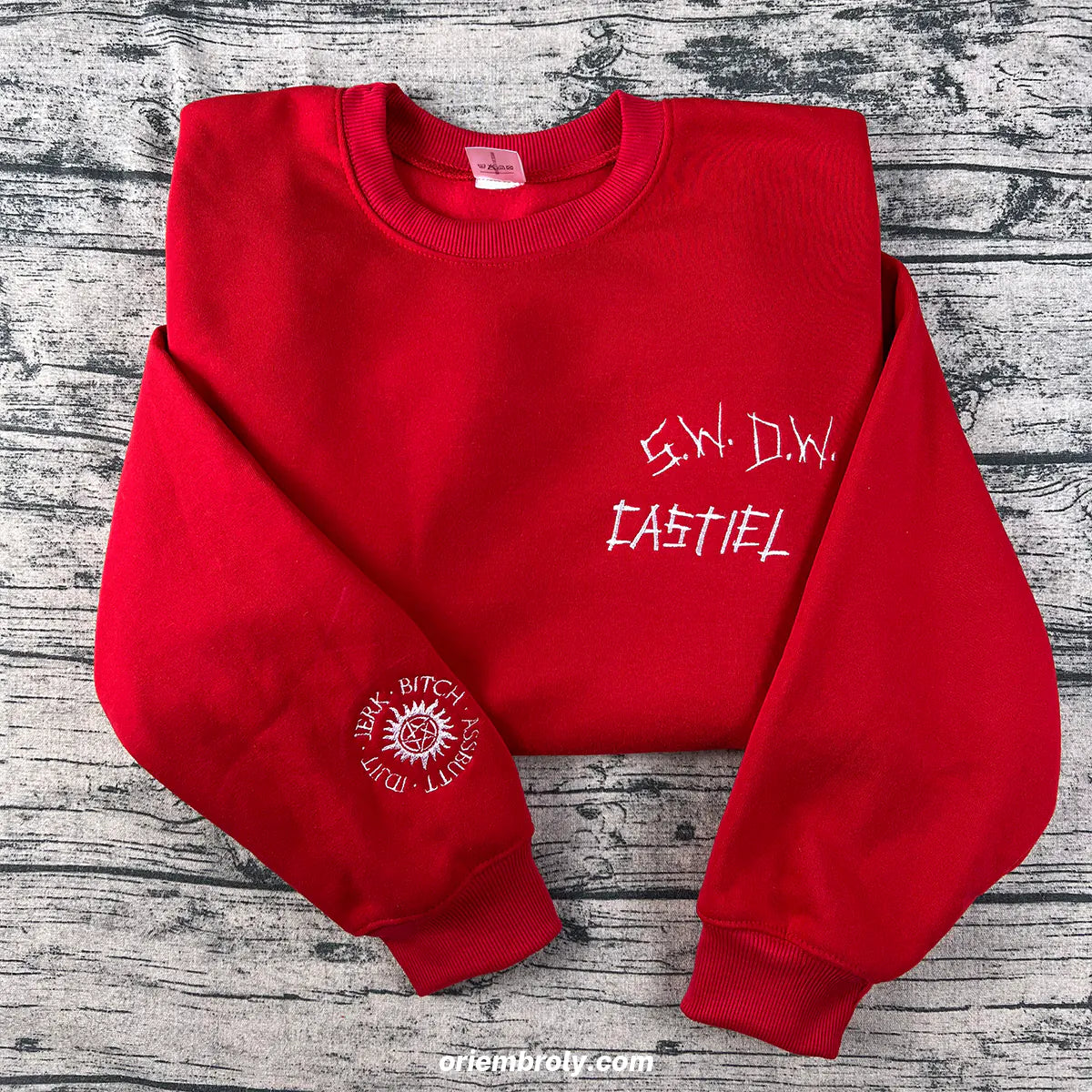 Red sweatshirt with white text on a wooden surface