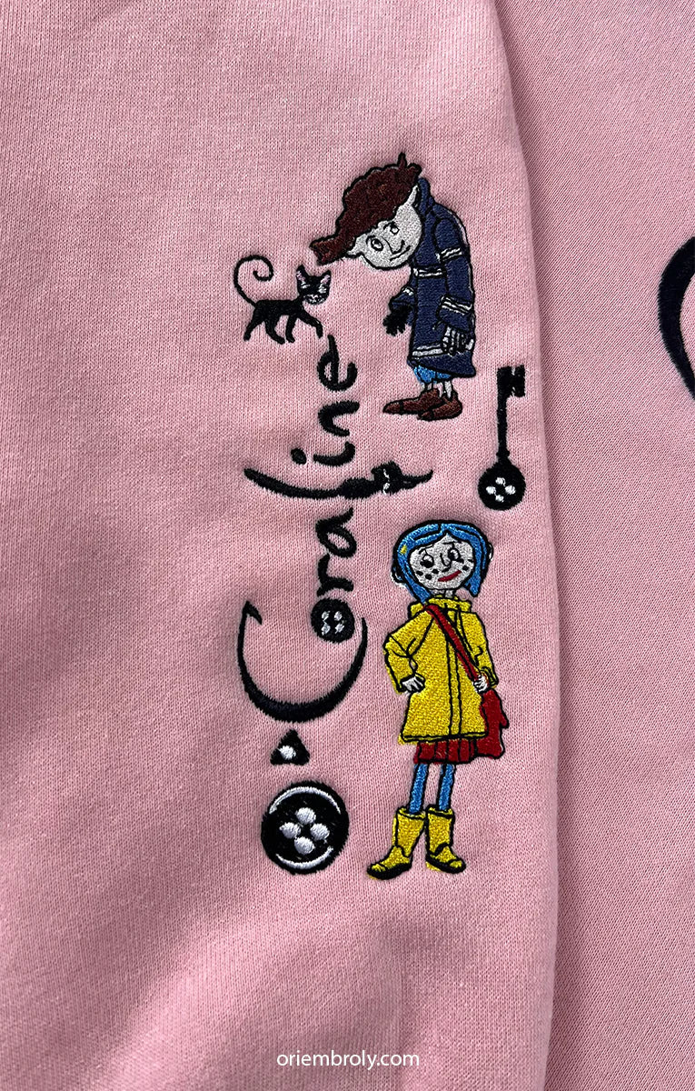 Embroidered design on a pink fabric with characters and text.