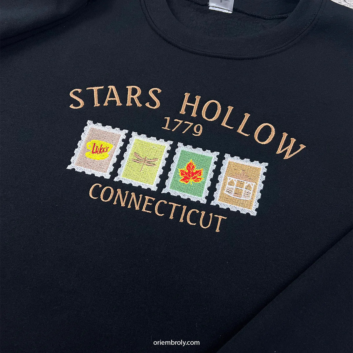 Black sweatshirt with 'Stars Hollow Connecticut' design featuring four embroidered stamps.