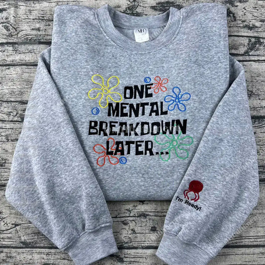 Gray sweatshirt with colorful text and designs on a wooden surface