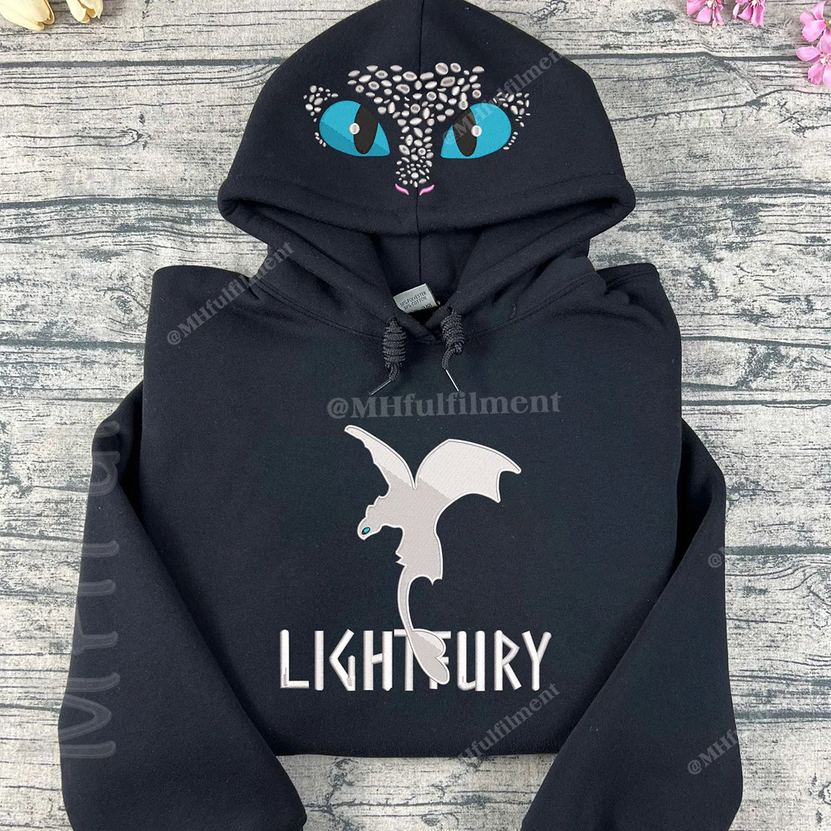 Black hoodie with a dragon design and 'LIGHTFURY' text on a wooden surface.