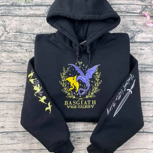 Black hoodie with dragon design and text on a wooden surface