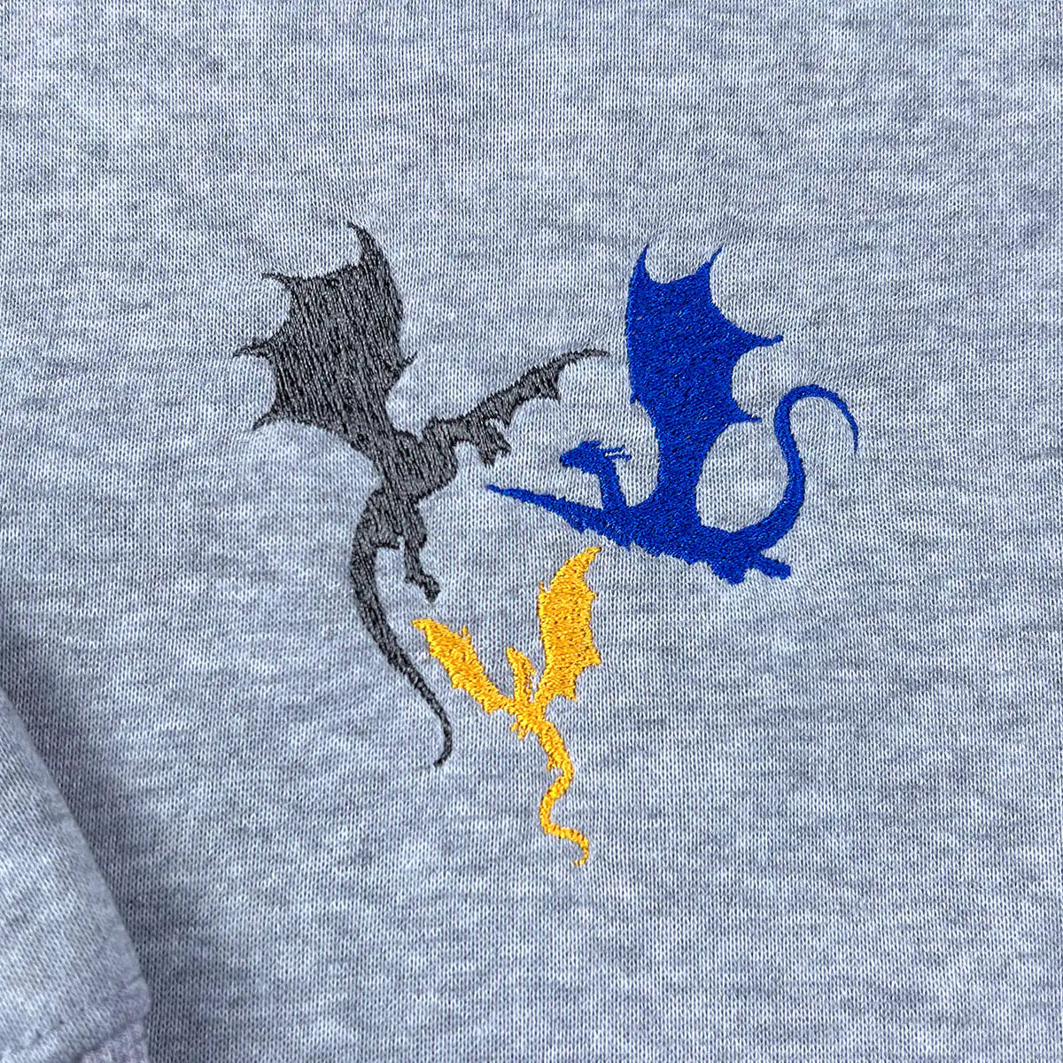 Basgiath War College Crewneck featuring Tiny Dragons embroidery, ideal for fans of the Fourth Wing series and bookish gifts.