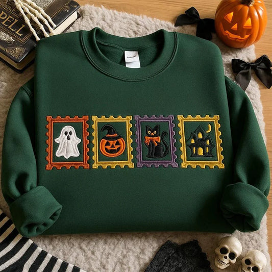 Green sweatshirt with Halloween-themed patches on a textured surface with pumpkins and books.