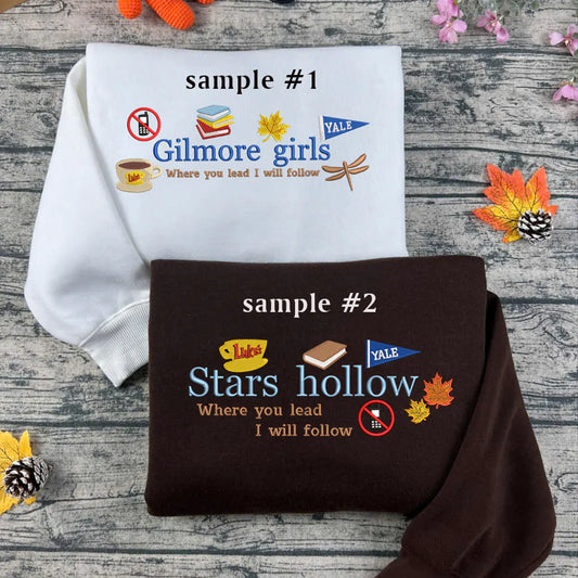 Two sweatshirts with 'Gilmore Girls' and 'Stars Hollow' text and graphics on a wooden surface.