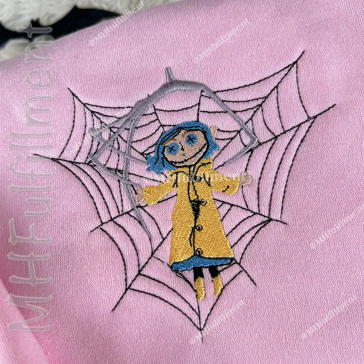 Embroidered design of a person in a yellow raincoat on a pink fabric with 'MHFulfillment' branding.