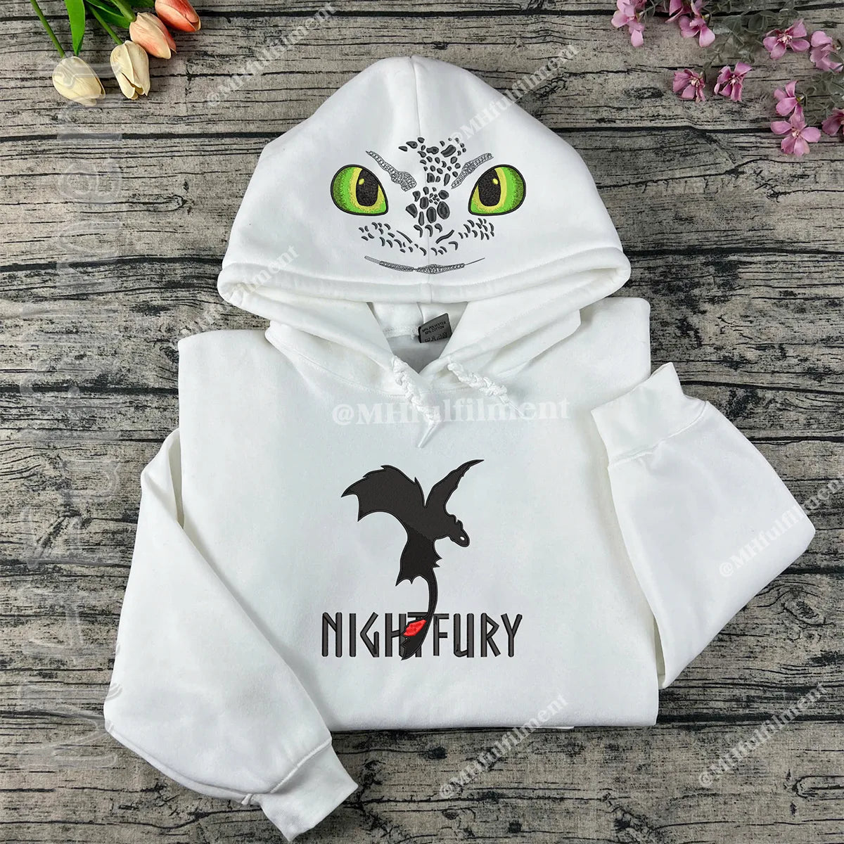 White hoodie with dragon design on a wooden surface
