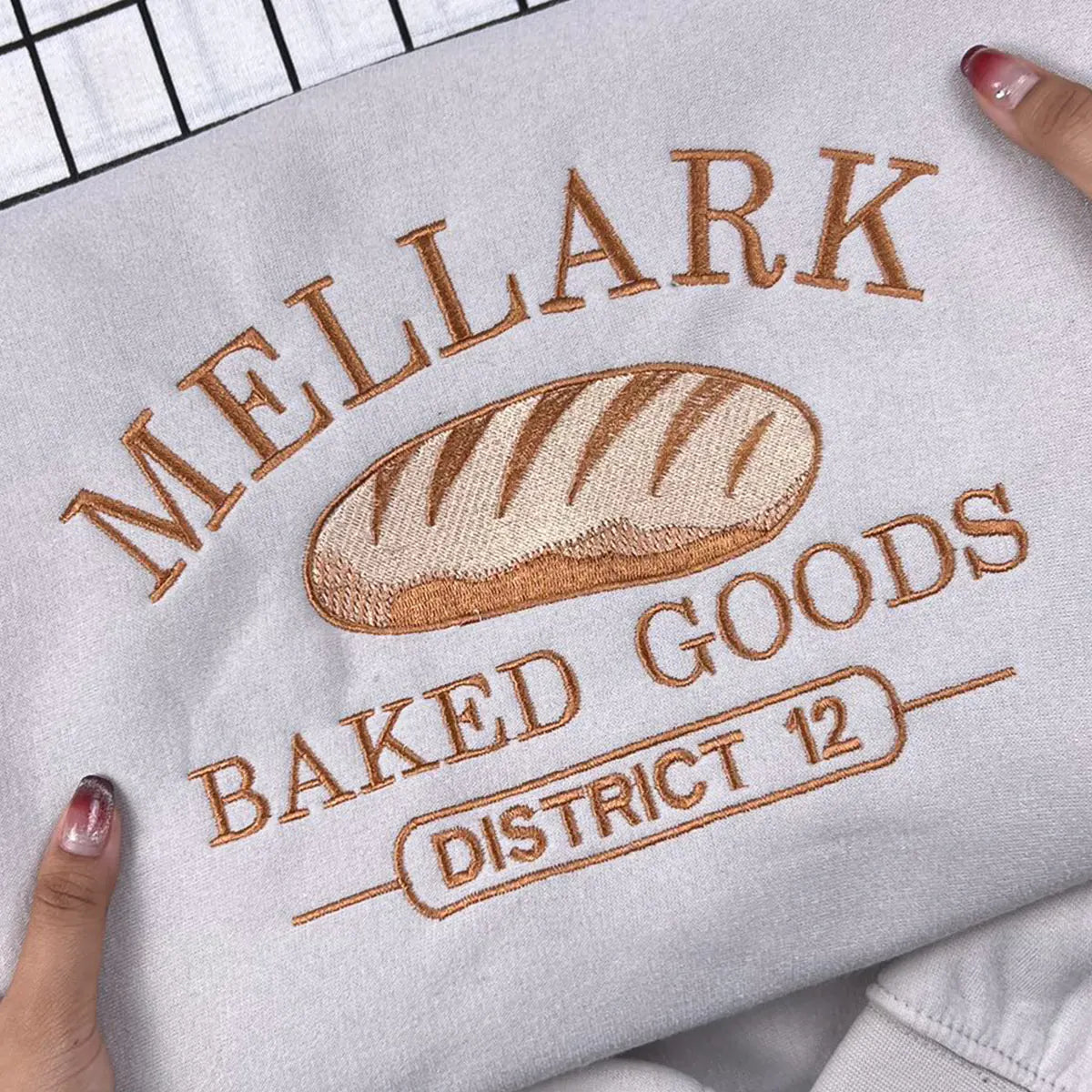 Bookish fan gift embroidered Mellark Baked Good Sweatshirt, Hunger Games hoodie with Abanathy Liquors design.