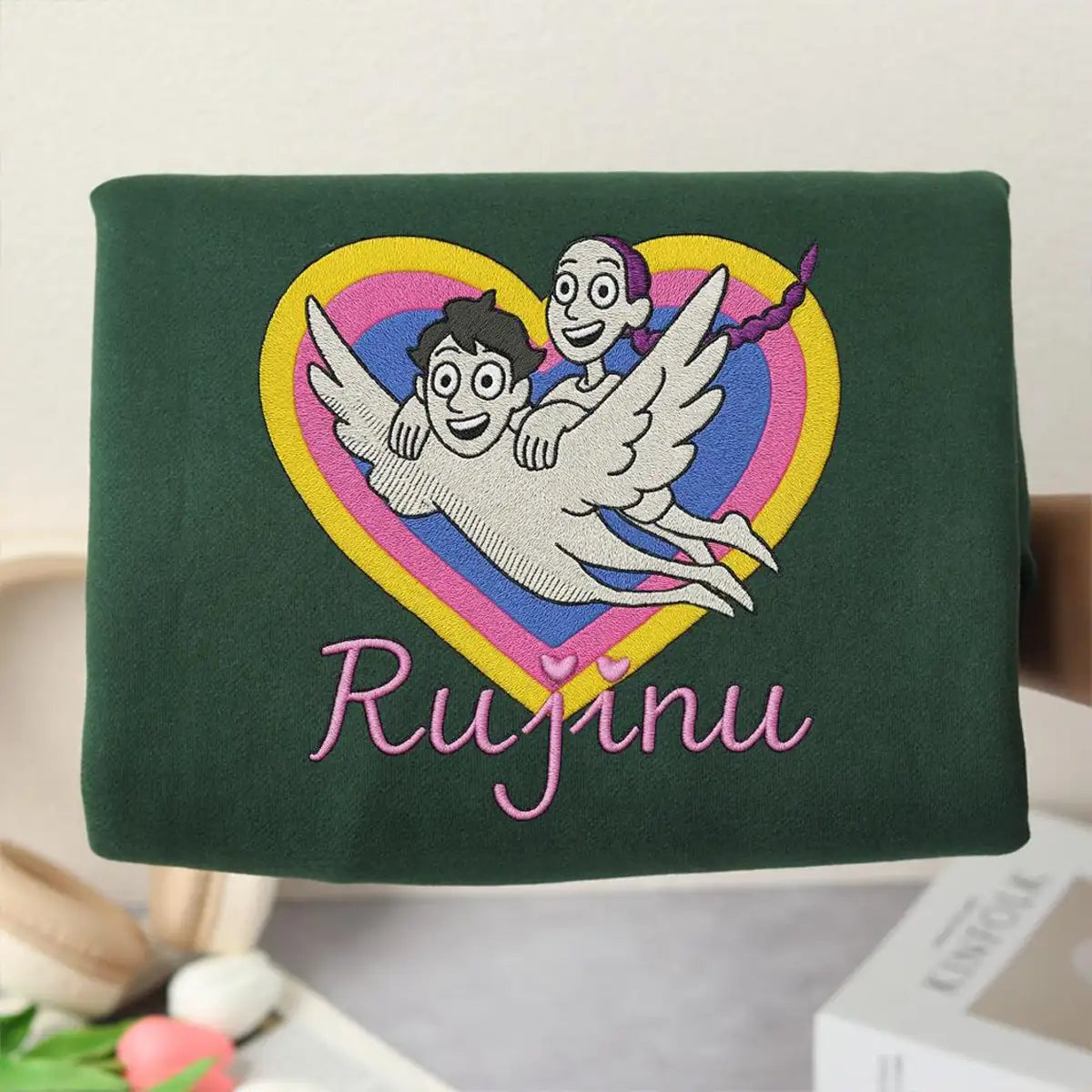 Green bag with embroidered design and 'Rujinu' text on a light background