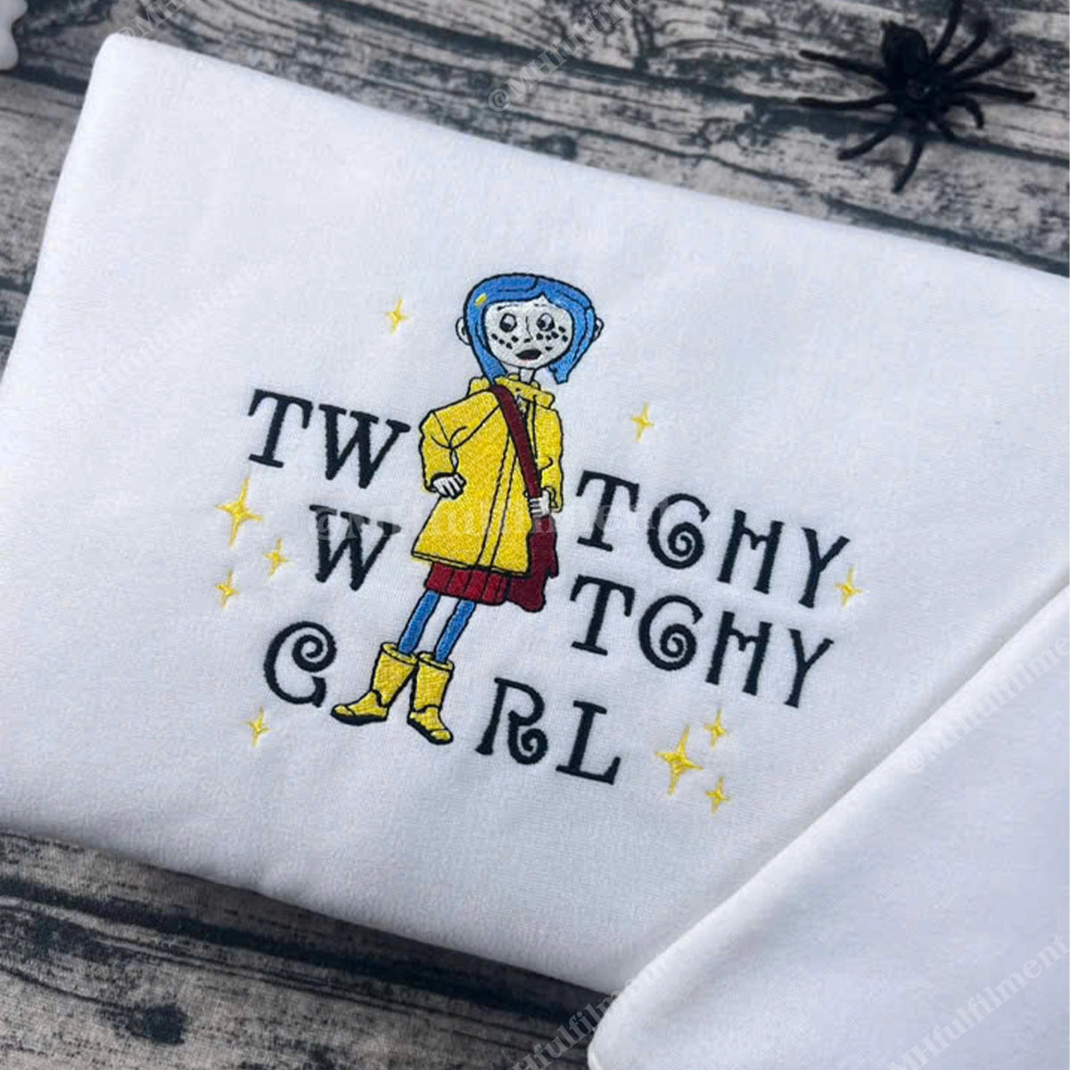 Embroidered design of a character with text on a white fabric background