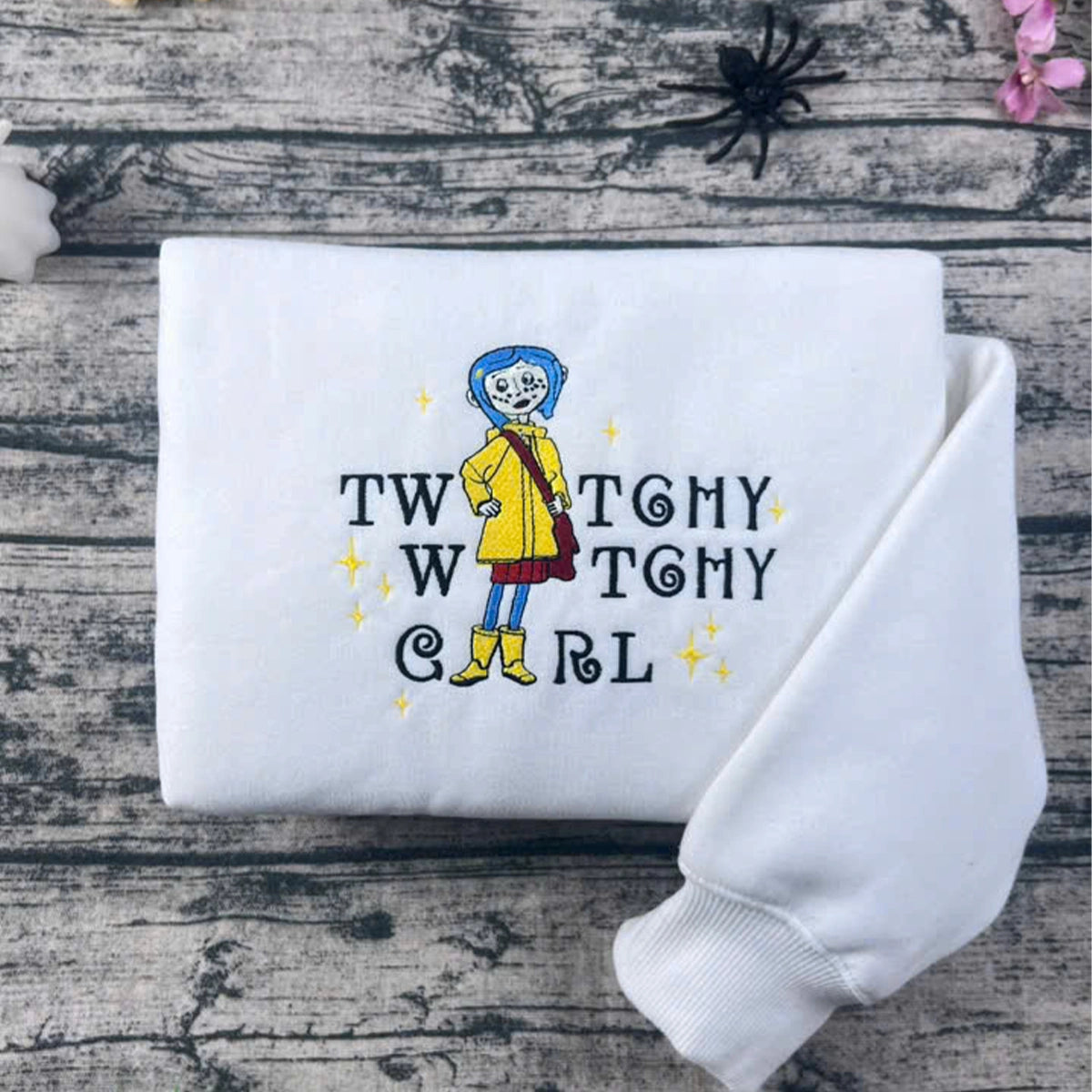 White sweatshirt with a colorful graphic and text on a wooden surface