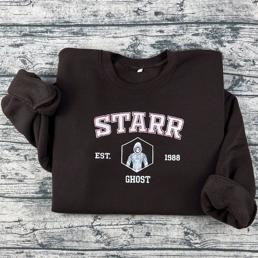 Black sweatshirt with 'STARR' and 'GHOST' text on a wooden surface