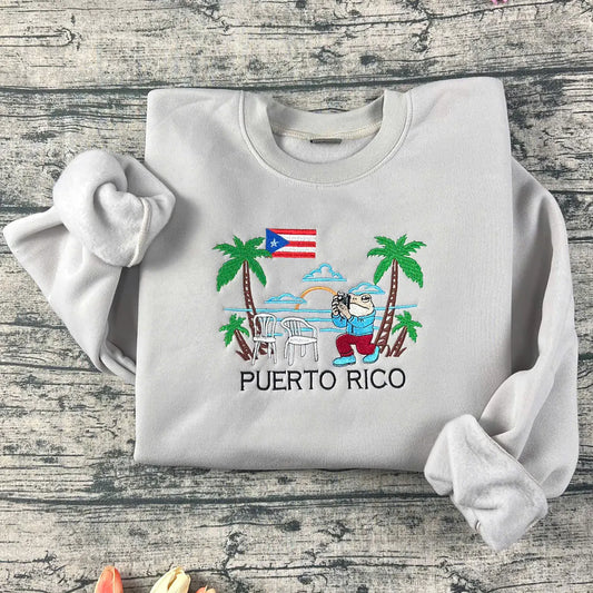 Folded gray sweatshirt with Puerto Rico-themed design on a wooden surface
