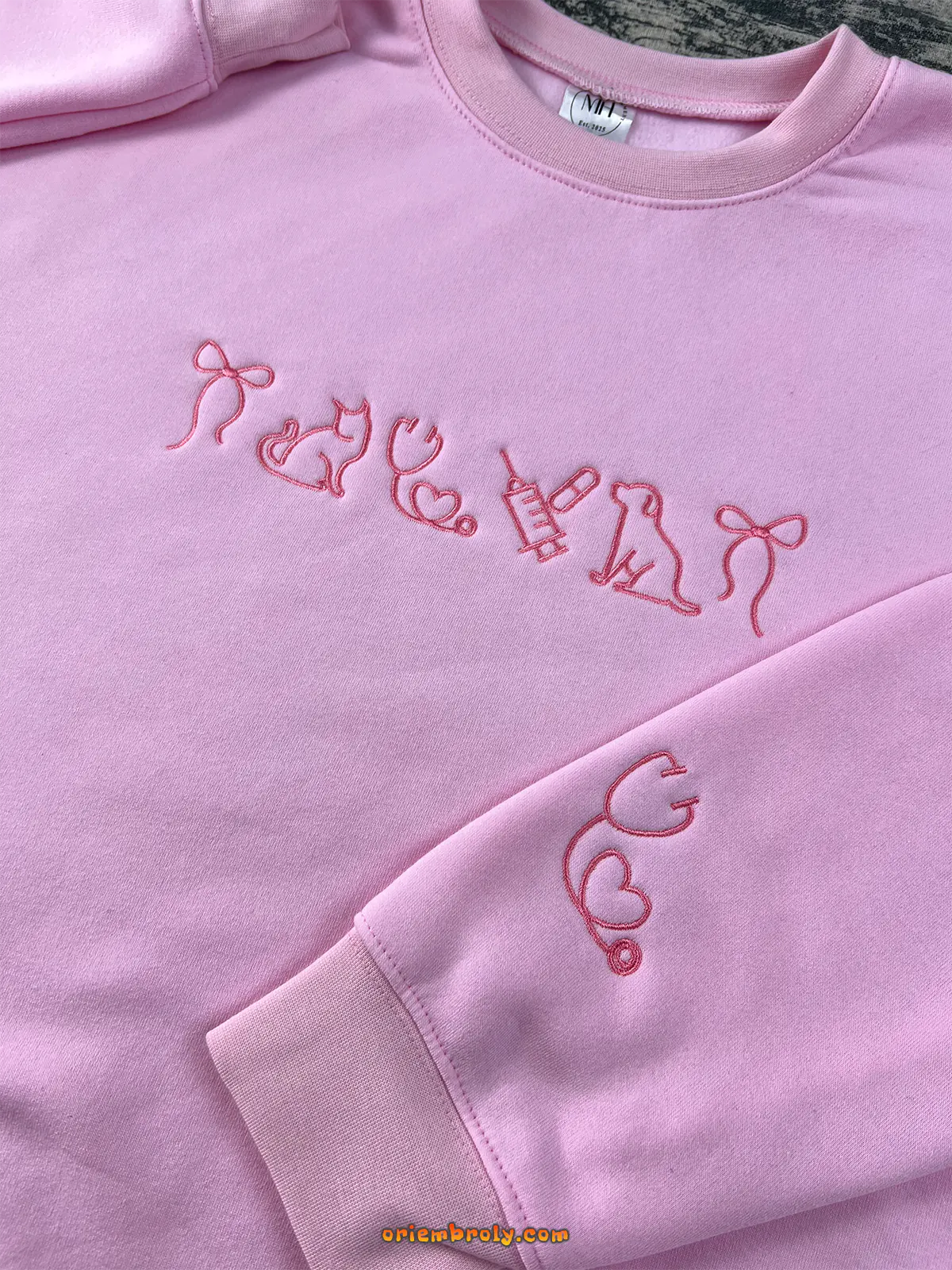 Light pink embroidered sweatshirt with cat, dog, and stethoscope designs — a cozy gift for veterinary lovers.