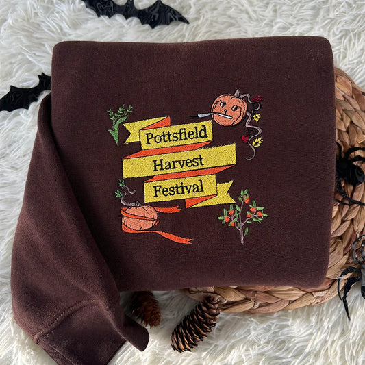 Brown sweatshirt with 'Pottsfield Harvest Festival' design on a textured surface.