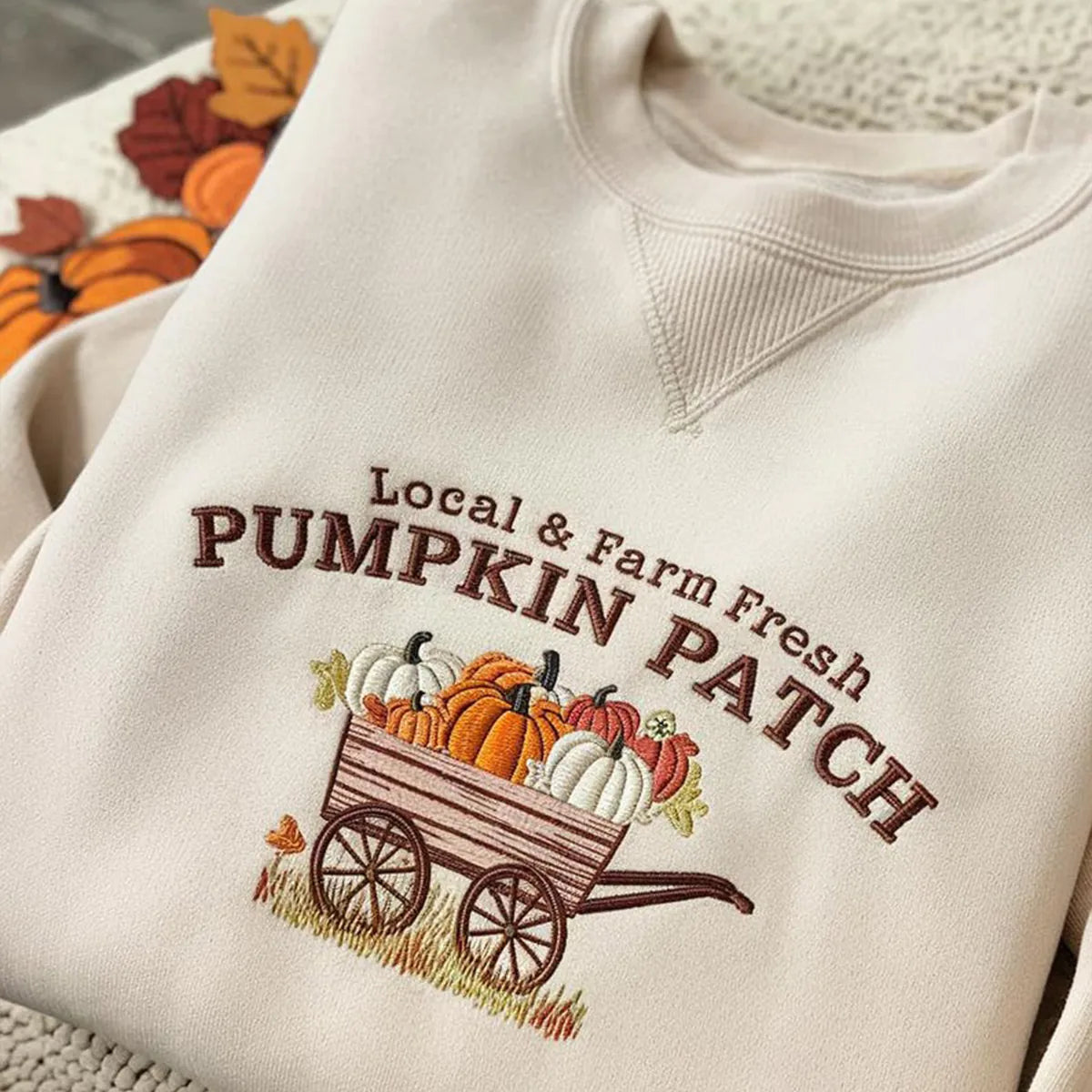 Beige sweatshirt with 'Local & Farm Fresh Pumpkin Patch' embroidery design.