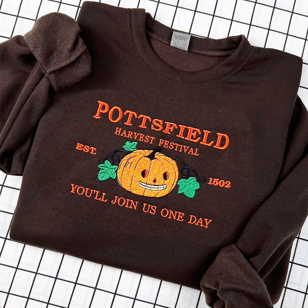 Embroidered Pottsfield Harvest Festival sweatshirt with spooky pumpkin carver design