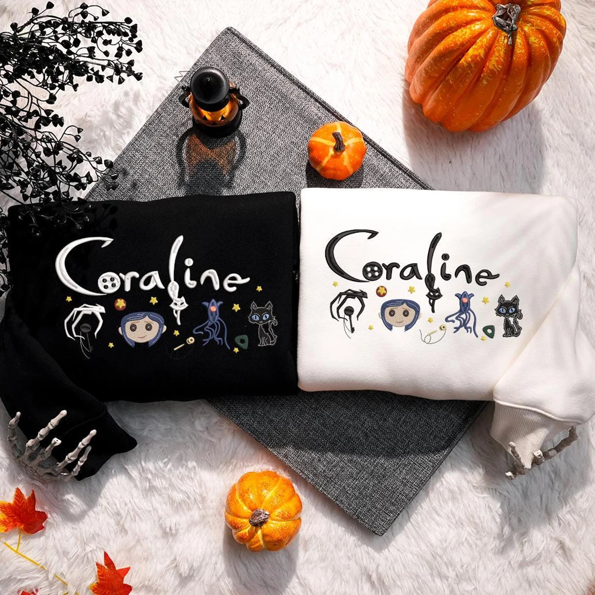 Two shirts with 'Coraline' design on a white surface with pumpkins and decorative elements.
