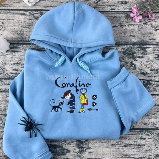 Light blue hoodie with cartoon characters and text on a wooden surface