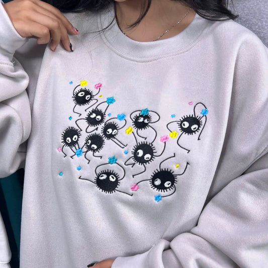 Person wearing a light gray sweatshirt with cartoon character design