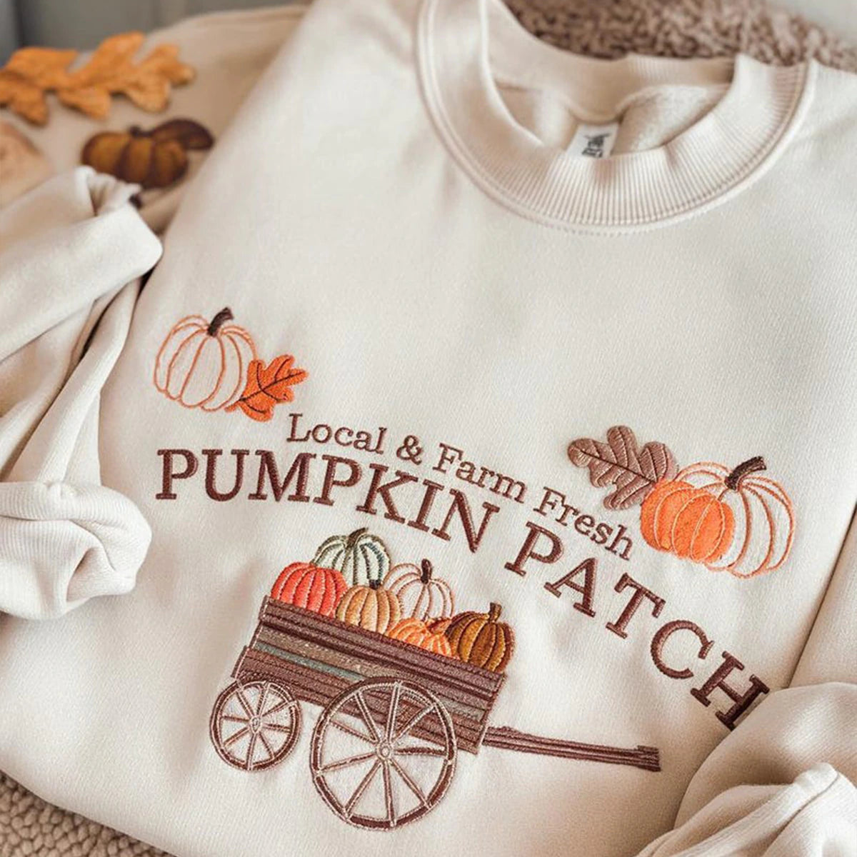 Beige sweatshirt with 'Local & Farm Pumpkin Patch' design featuring pumpkins and a cart.