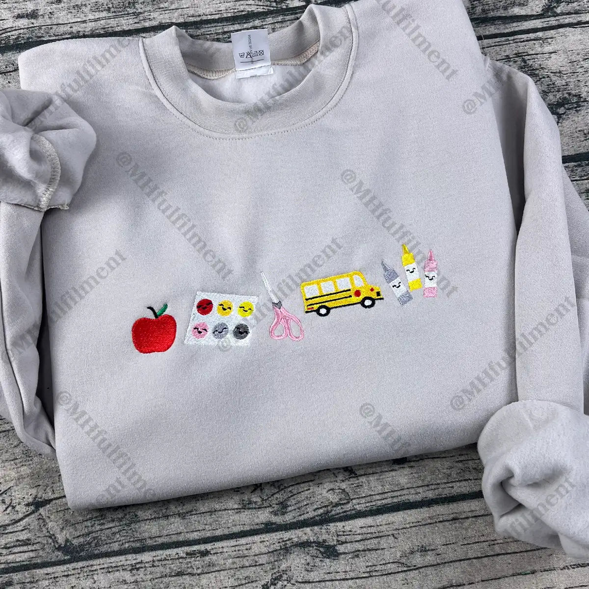Gray sweatshirt with various colorful patches on a wooden surface