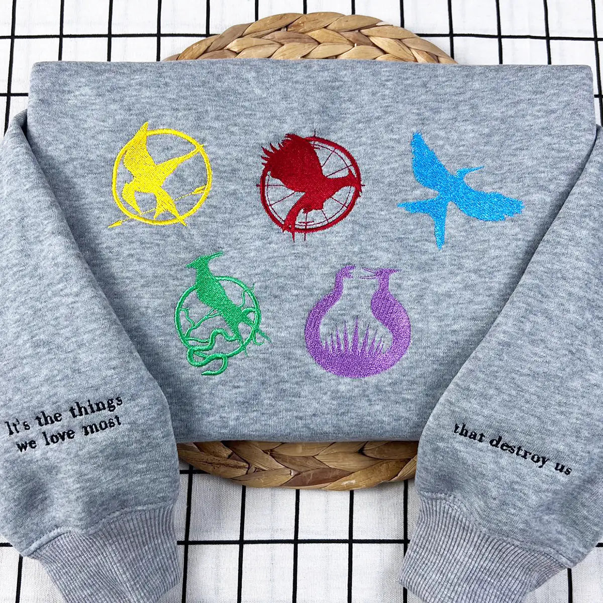 The Hunger Games embroidered sweatshirt featuring Mockingjay, Catching Fire, and Ballad of Songbirds & Snakes design