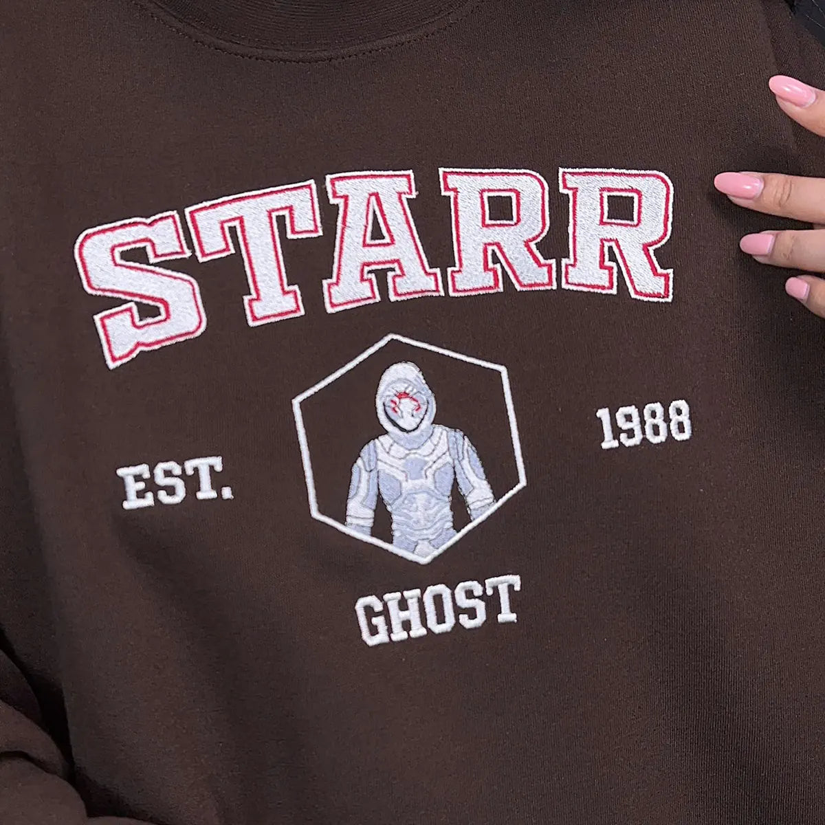 Brown sweatshirt with 'STARR' and 'GHOST' design on a dark background