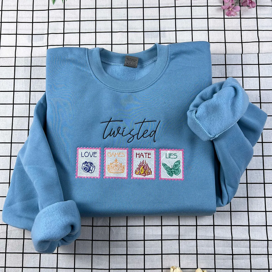 Blue sweatshirt with embroidered designs and text on a checkered background
