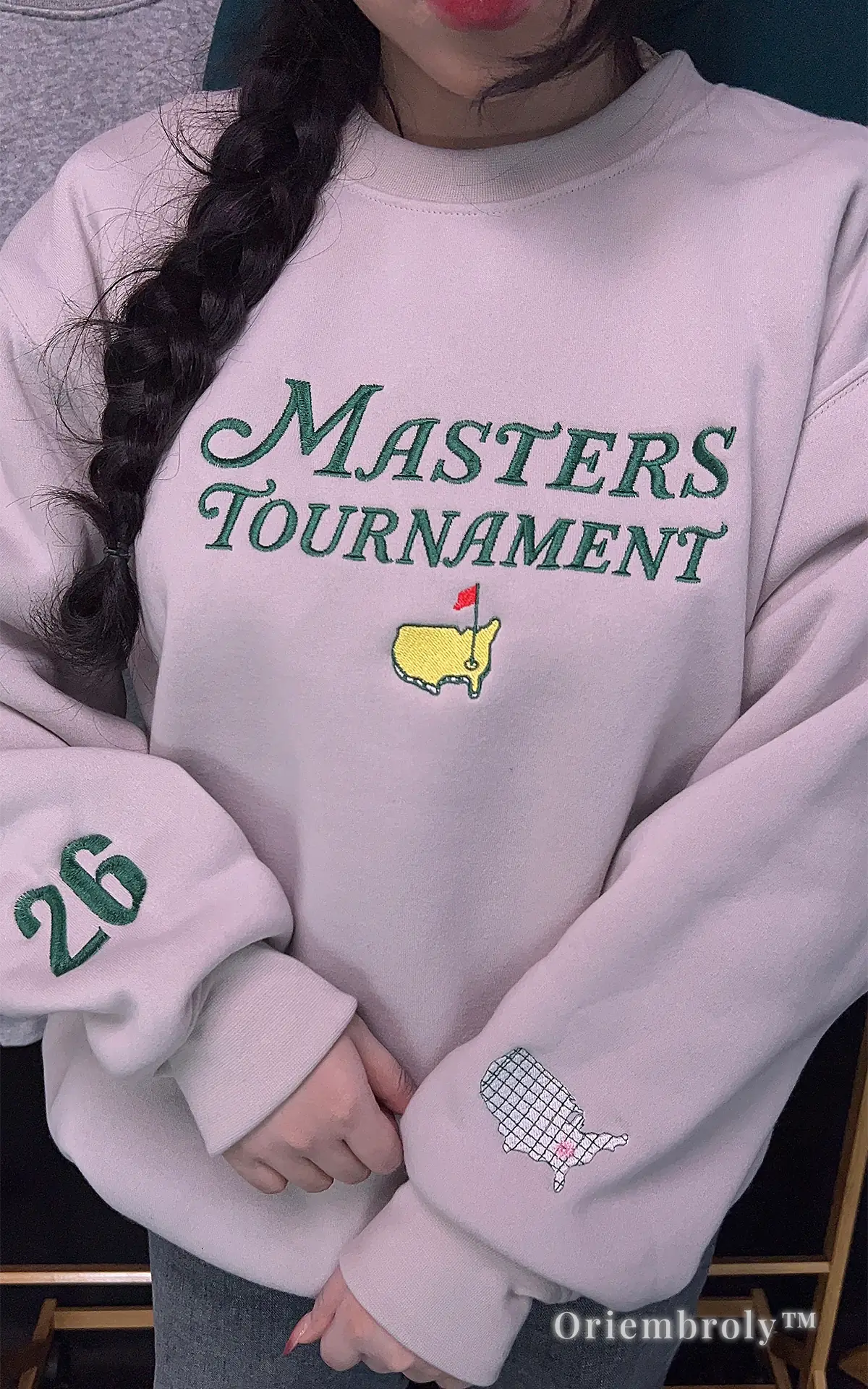 Detailed embroidery of the Masters Tournament on an off-white crewneck. A unique and high-quality gift idea for golfers, featuring a vintage-inspired design and premium satin stitching