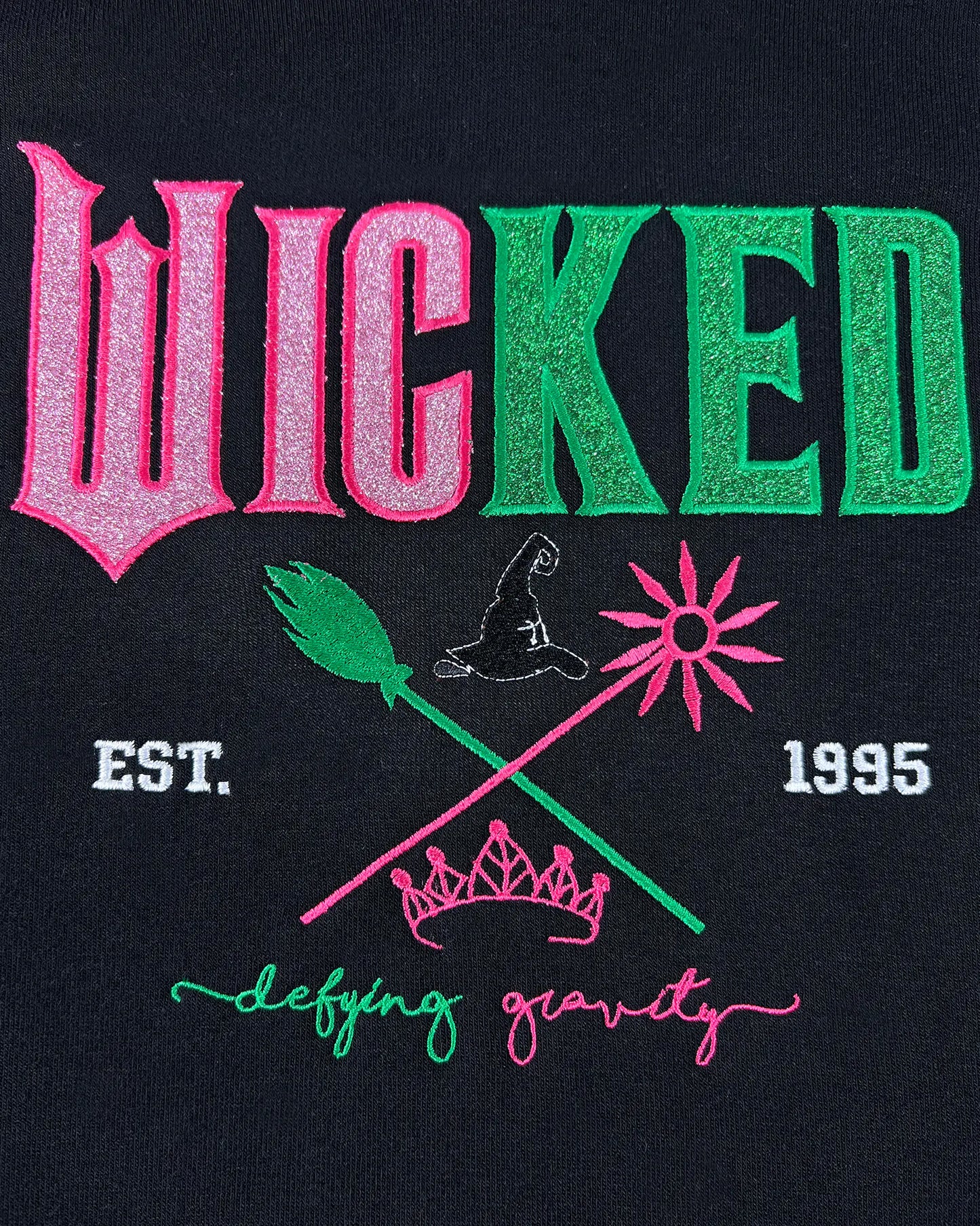 Wicked embroidered hoodie with Defy Gravity applique, inspired by Glinda and Elphaba. Cozy Halloween sweatshirt and witch gift idea for women.