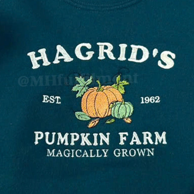 Green sweatshirt with 'Hagrid's Pumpkin Farm' text and pumpkins on a wooden surface