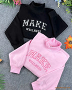 Stack of grey mock neck sweatshirts with custom red and blue embroidered applique letters