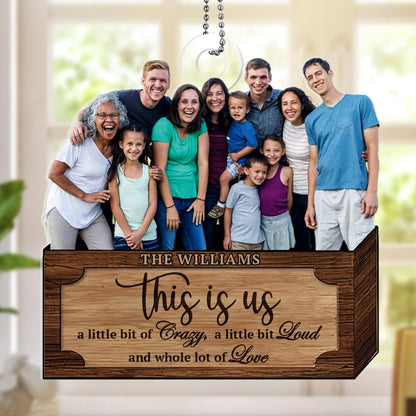 A personalized acrylic Christmas ornament featuring a photo of the large Williams family and text that reads 'This is us, a little bit of Crazy, a little bit Loud and whole lot of Love'. This custom family keepsake is a unique holiday gift idea.