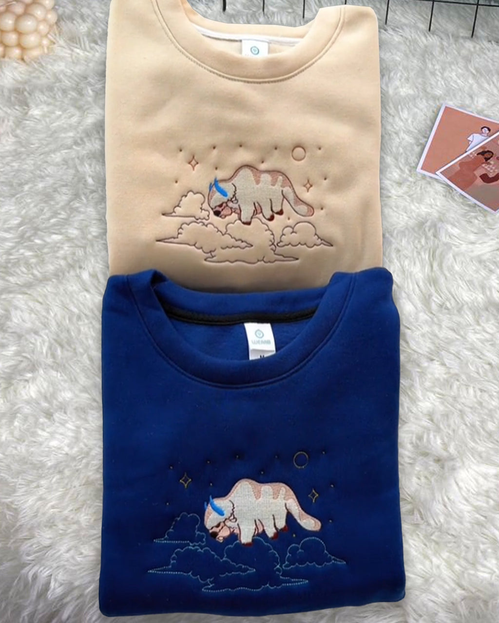Appa sky bison flying through clouds and stars anime embroidered vintage crewneck sweatshirt in beige and royal blue