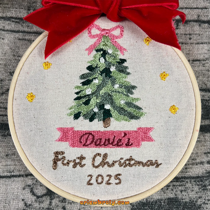 Embroidery hoop with a Christmas tree design and 'David's First Christmas 2025' text, featuring a red bow.