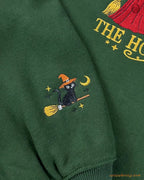 Close-up of custom sleeve embroidery featuring a black cat wearing a orange witch hat flying on a broomstick