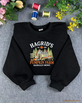 Flatlay view of a black crewneck sweatshirt embroidered with Hagrid's Pumpkin Farm Magically Grown autumn design.