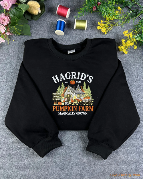 Flatlay view of a black crewneck sweatshirt embroidered with Hagrid's Pumpkin Farm Magically Grown autumn design.