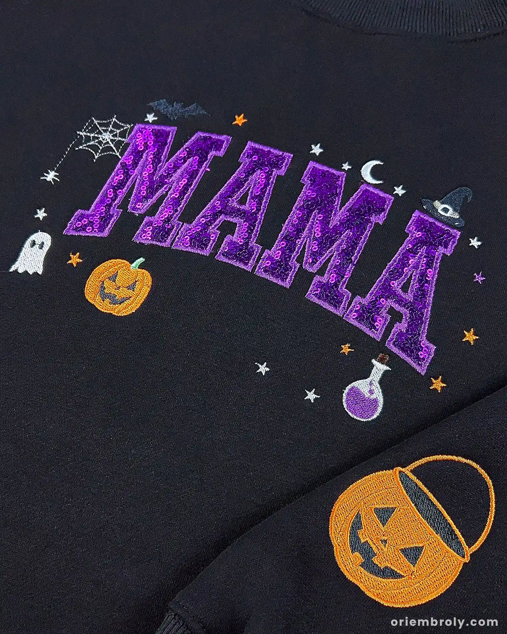Close-up of black Mama Halloween sweatshirt featuring shiny purple sequin letters, ghostly graphics, and pumpkin sleeve detail.
