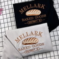 Embroidered Mellark Baked Good Sweatshirt, Hunger Games Inspired Hoodie featuring Abanathy Liquors design, perfect for bookish fans.