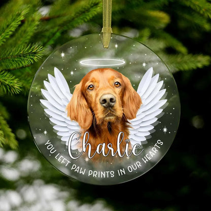 A personalized dog memorial Christmas ornament featuring a Golden Retriever named Charlie with angel wings and a halo, and the text "You left paw prints in our hearts". This text helps describe the image for visually impaired users and includes relevant keywords for search engine optimization.