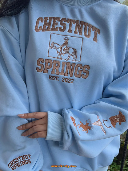 Light blue sweatshirt with 'Chestnut Springs' text and graphics on a person wearing it.