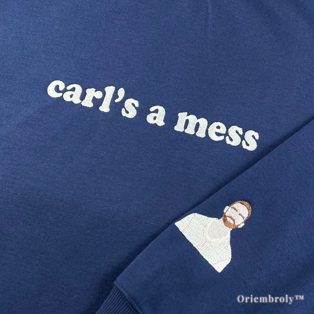 Close-up of premium white satin stitch embroidery reading "carl’s a mess" on a heavyweight navy sweatshirt. Durable, textured thread work designed for a premium feel and long-lasting wear