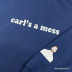 Close-up of premium white satin stitch embroidery reading "carl’s a mess" on a heavyweight navy sweatshirt. Durable, textured thread work designed for a premium feel and long-lasting wear