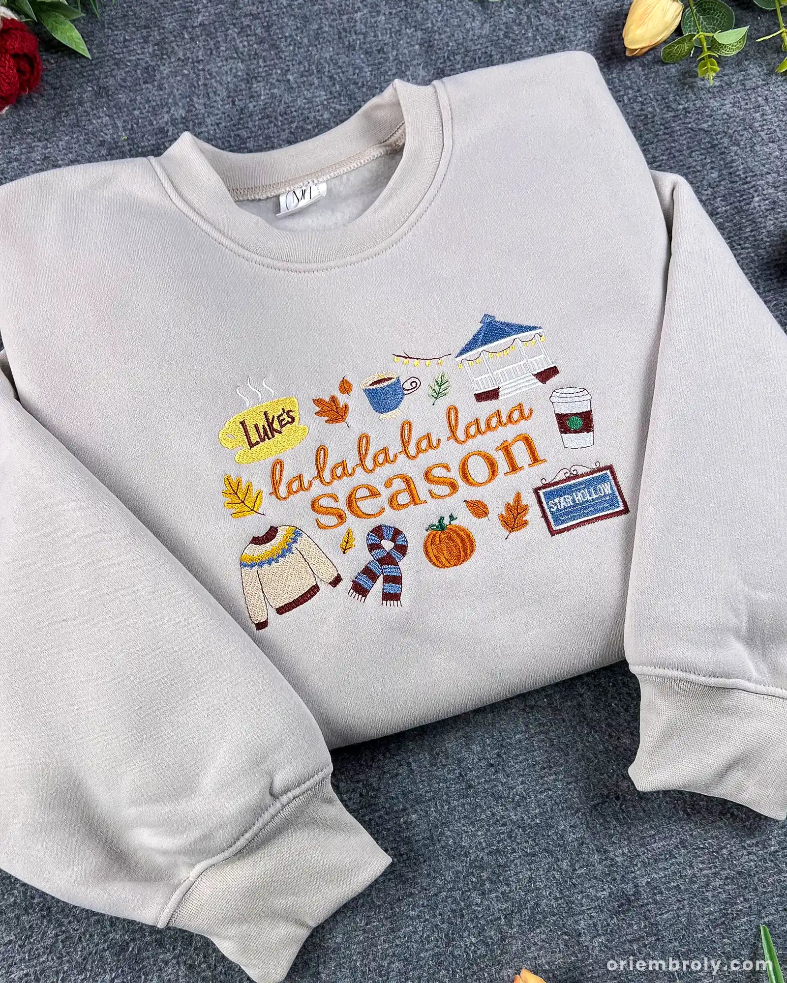 Angled view of cozy light gray La La La Season embroidered pullover sweatshirt with autumn vibes.