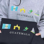 Gray sweatshirt and black bag with embroidered Guatemala designs.
