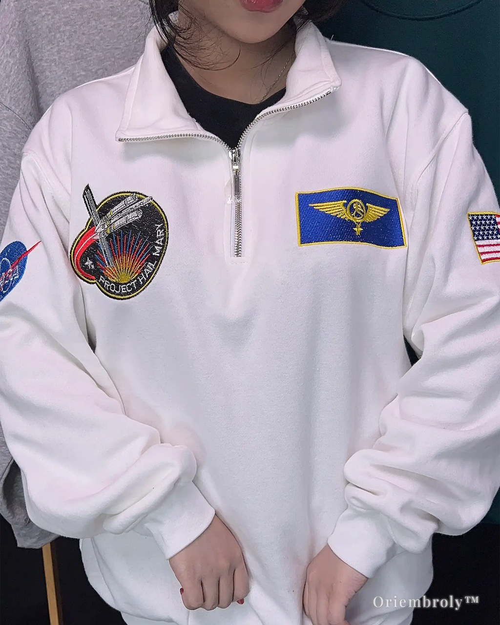 Cozy white fleece quarter-zip sweatshirt with vibrant embroidered space logos. Combines everyday comfort with a passion for cosmic exploration and NASA history.